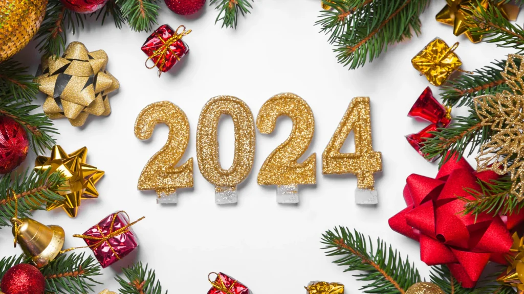 Happy New Year 2024 Greeting Card wallpaper. Candle Numbers on White Background and Layout of Christmas Tree Balls Gifts. Close up and Copy Space Selective Focus