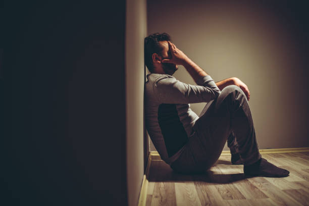 young depressed man sitting on floor