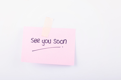 business message see you soon written on notepad over white background