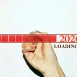 Woman hand with glitter nails showing the Loading Bar with the year 2026