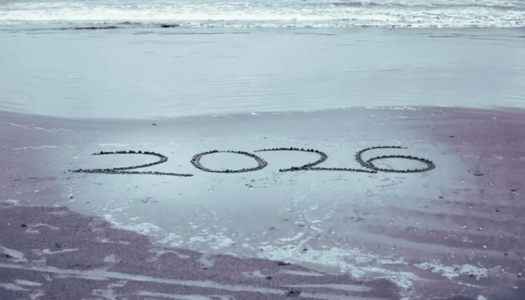 hand write 2026 on sea beach with 2026 written in the sand