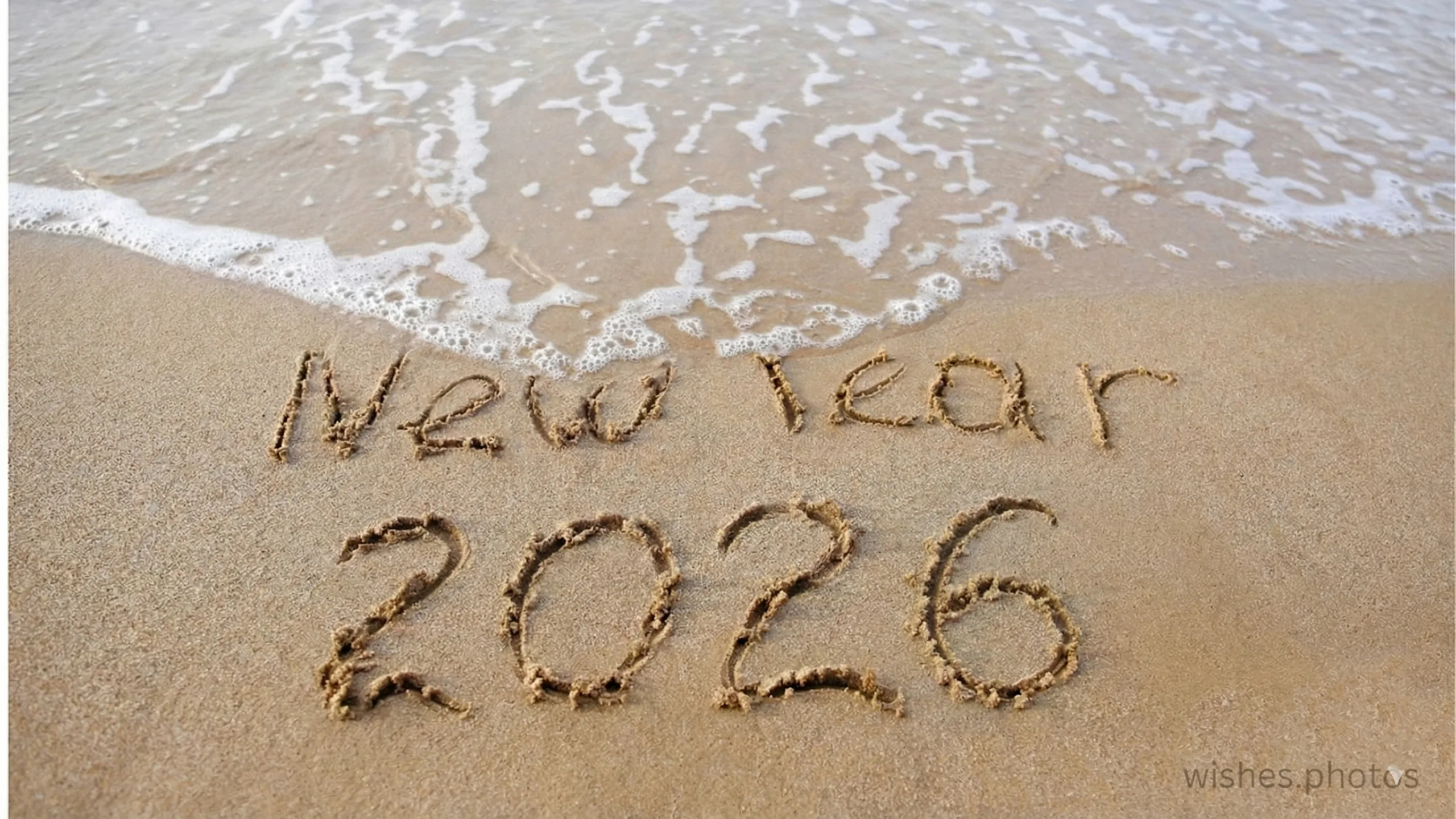 The inscription 2026 on the sand by the sea. Happy New Year. wishes.photos The inscription 2026 on the sand by the sea. Happy New Year. wishes.photos