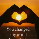 A sunset silhouette of two hands forming a heart — “You changed my world beautifully.”