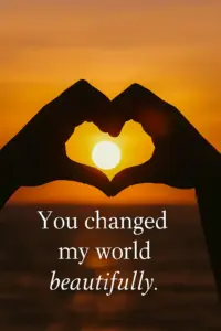 A sunset silhouette of two hands forming a heart — “You changed my world beautifully.”